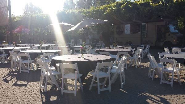 Lucky Slice Pizza truck and round tables linens and with chairs in the Amp plaza