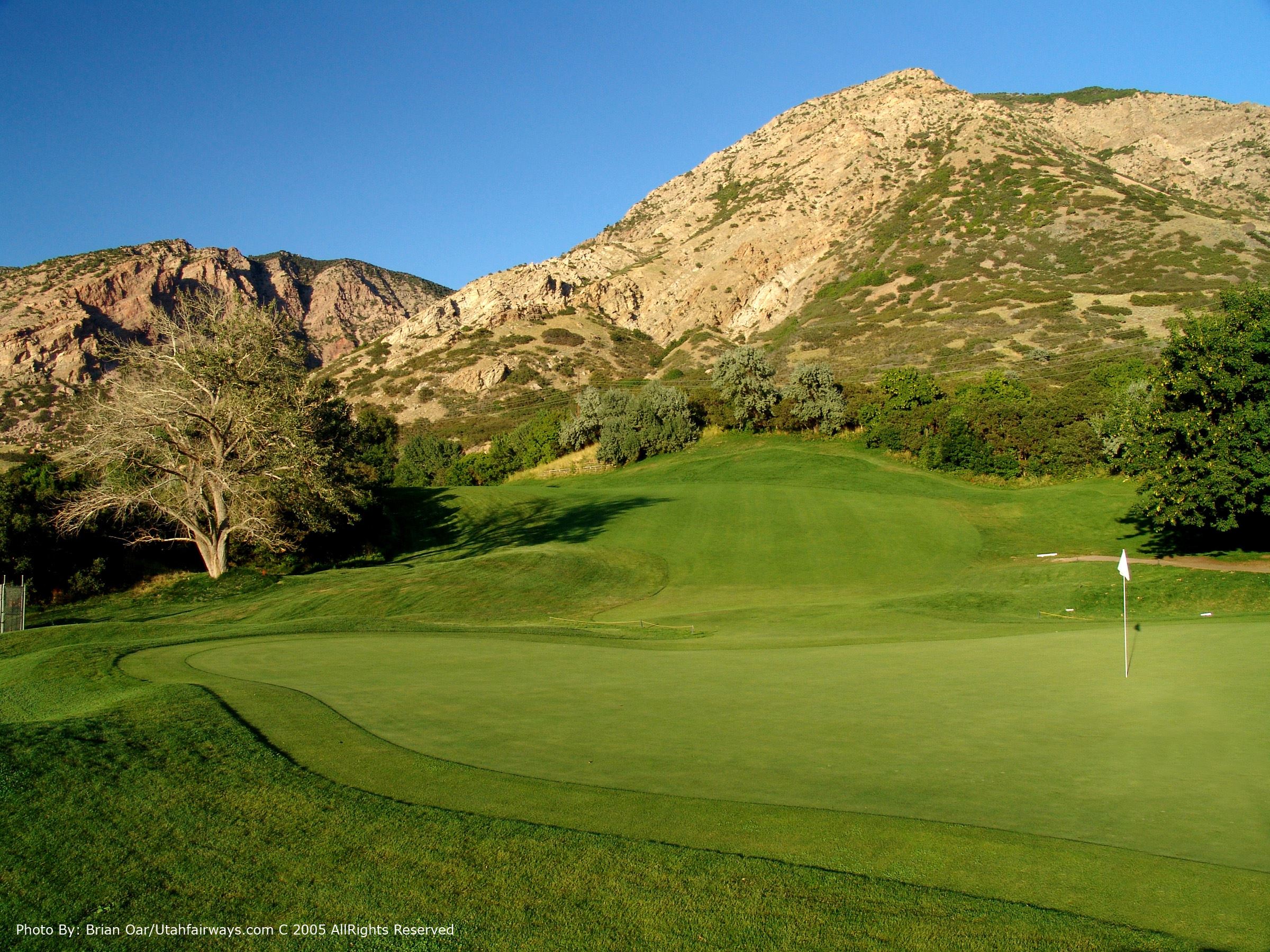 One of the greens at Mount Ogden Golf Course with a mountain in the background.