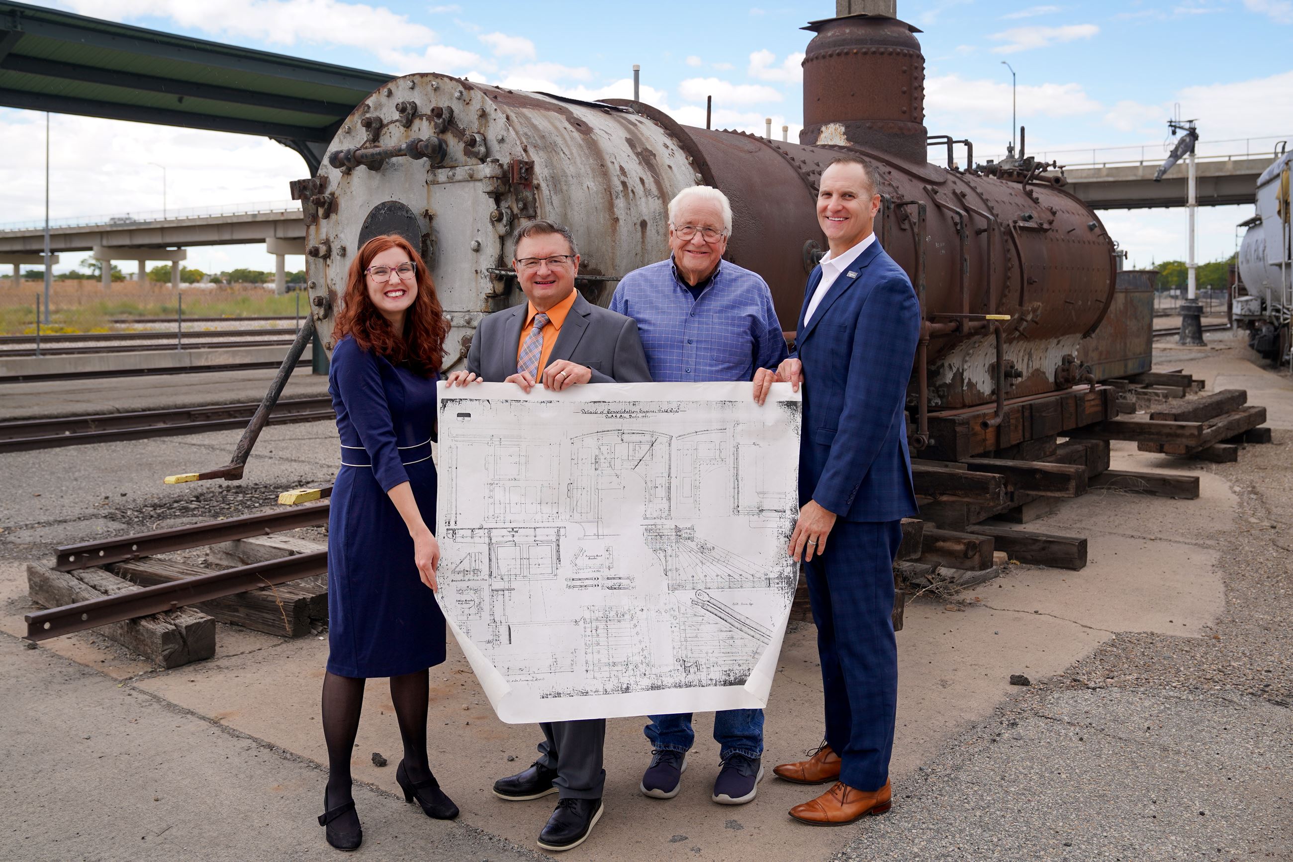 Leadership of Ogden City and the 223 Locomotive Foundation Pose in front of train boiler